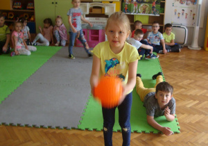 Dziewczynka celuje piłką do kosza